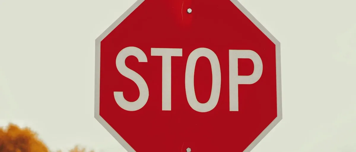 A red stop sign against a plain sky